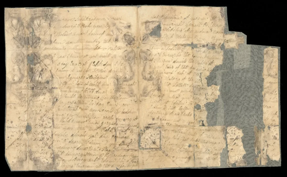 A fragmented relic, part of the Peglar papers, this shows a damaged and yellowing document covered in brownish grey writing